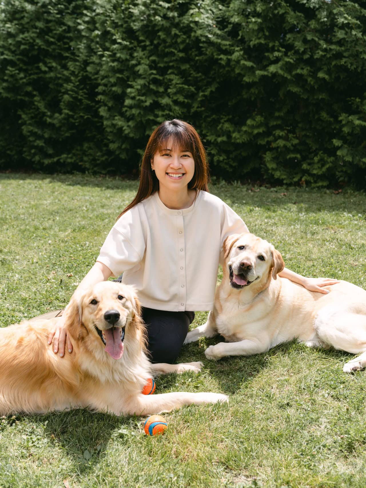 athy sitting with her two dogs on grass